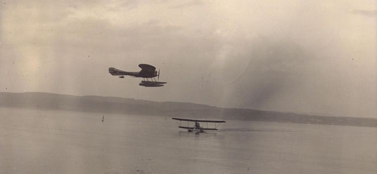 Die historische Aufnahme zeigt zwei Wasserflugzeuge, eines noch auf dem Wasser, das andere schon in der Luft. 