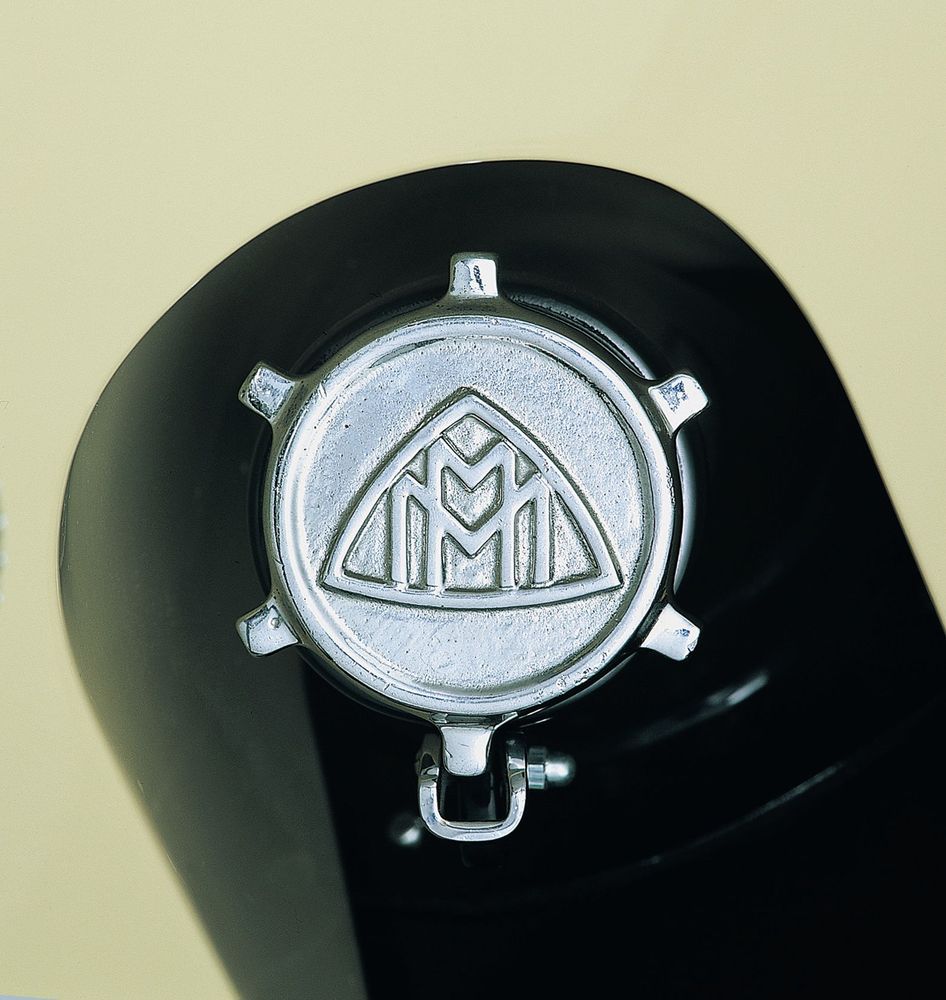 Die Aufnahme zeigt eine Detailaufnahme des Maybach-Emblems auf einem Tankdeckel.