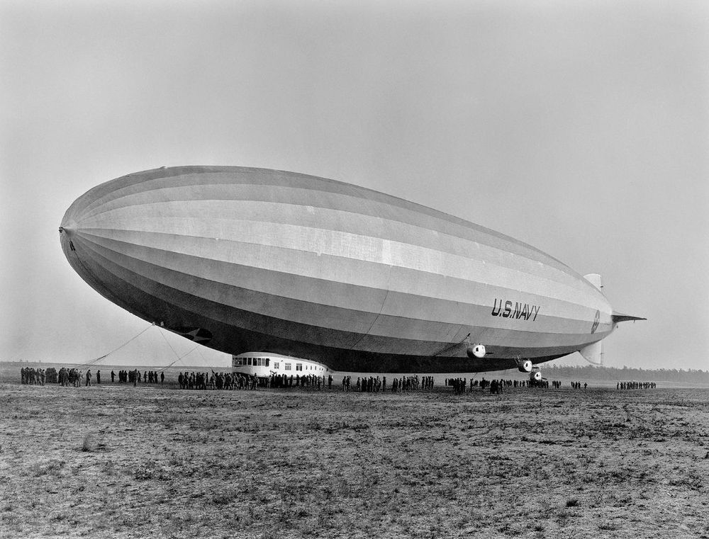 Das Luftschiff LZ 126 auf einer Wiese inmitten von zahlreichen Menschen.