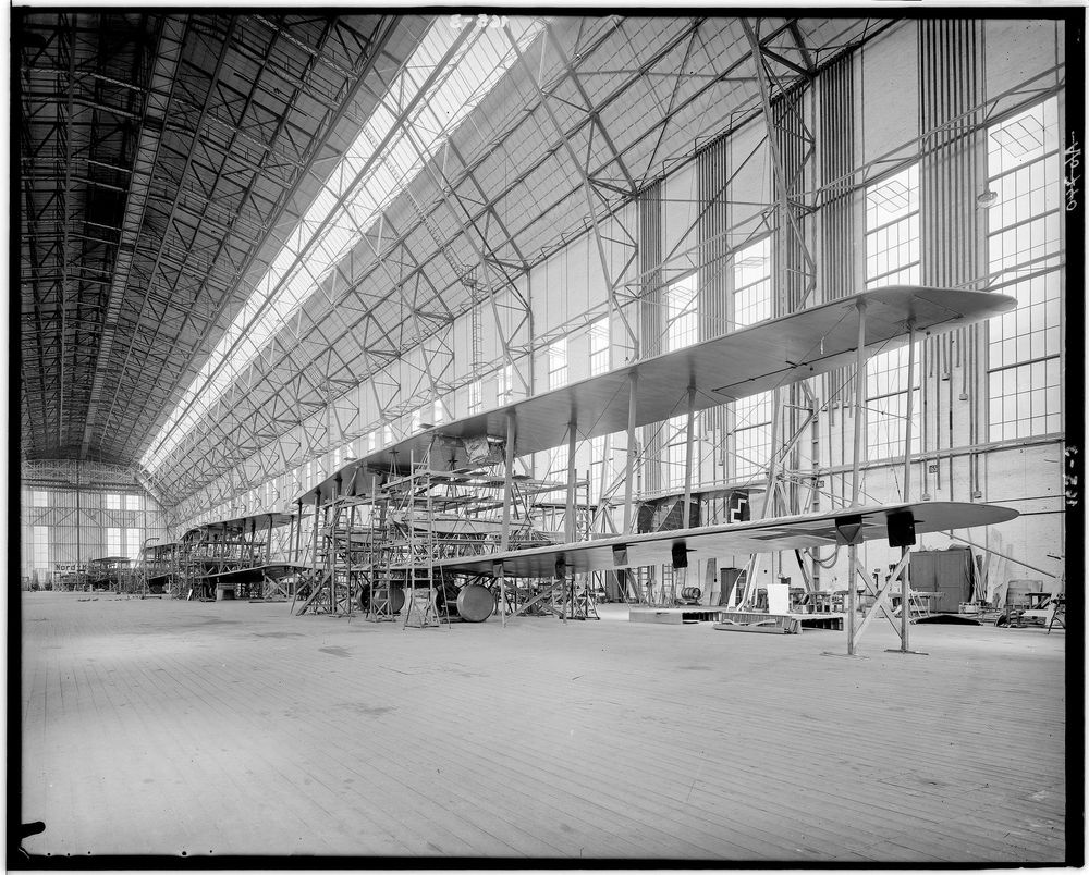 Die historische Aufnahme zeigt den Bau von Riesenflugzeugen in einer Luftschiffhalle.