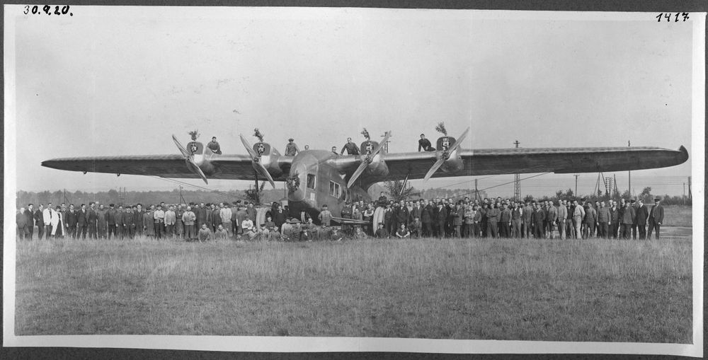 Die historische Aufnahme zeigt das Flugzeug E.4/20 mit der Belegschaft.