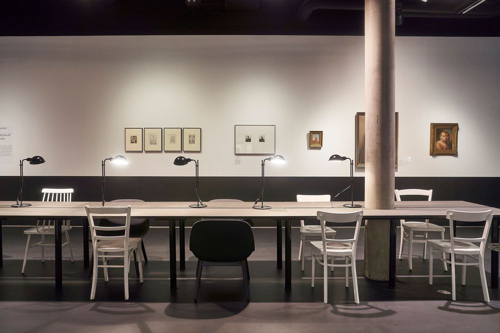 Ein langer Tisch mit Stühlen in der Ausstellung "Beziehungsstatus: Offen. Kunst und Literatur am Bodensee".