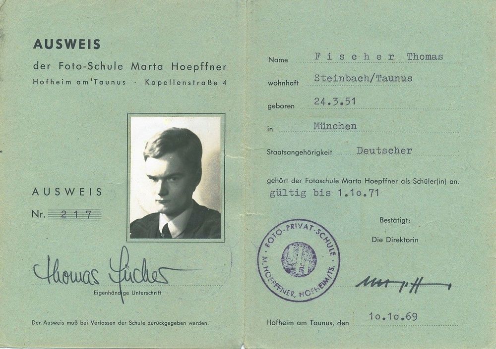 Die Abbildung zeigt den alten Schulausweis eines Mannes. Auf verblichenem grünen Papier stehen Angaben zur Person, außerdem ist ein schwarz-weiß Passfoto eingeklebt.