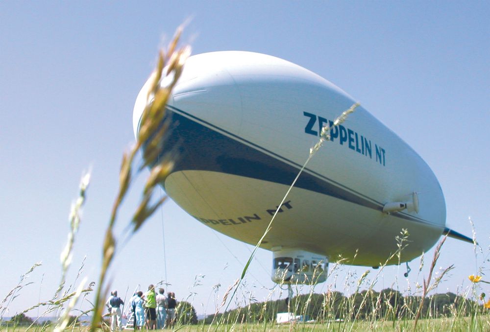 Eine Gruppe von Personen beobachtet die Landung des Zeppelin NTs.