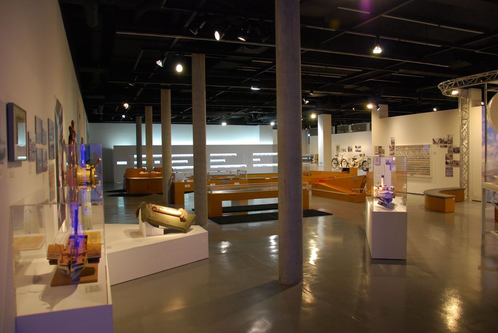 Die Ausstellungsansicht von "Wasser, Straße, Schiene, Luft. Mobilität am Bodensee" zeigt mehrere Vitrinen und Schaukästen, in denen Exponate ausgestellt sind. 