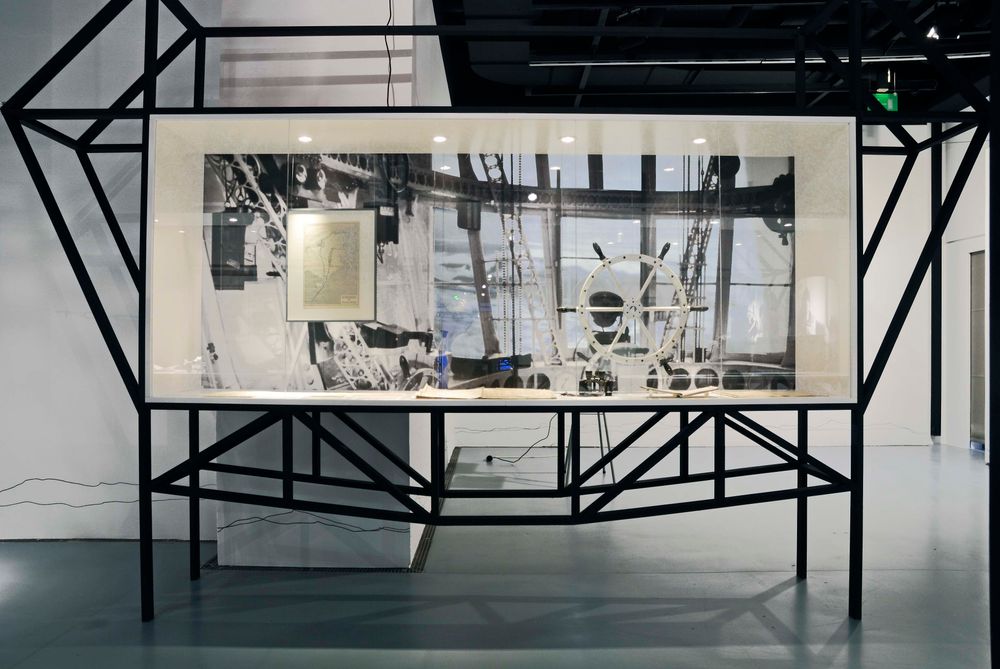 Die Ausstellungsansicht zu "66 Grad 30 Minuten Nord. Luftschiffe über der Arktis" zeigt eine große Vitrine, in der sich verschiedene Exponate befinden.