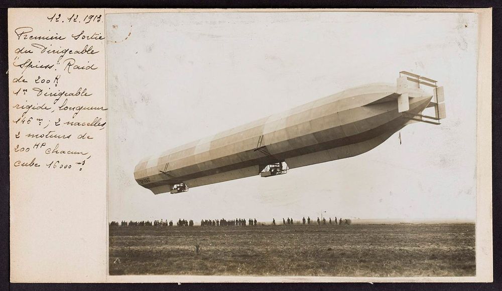 Die Aufnahme zeigt eine alte vergilbte Postkarte, auf der ein Zeppelin abgebildet ist und links etwas geschrieben steht.