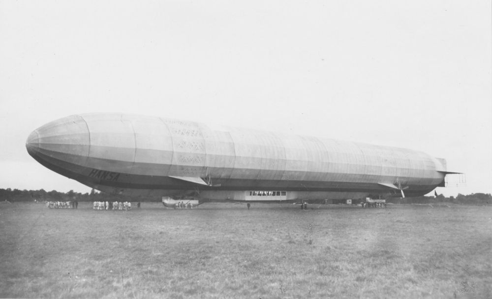 Die historische Aufnahme zeigt ein Luftschiff, das am Boden steht.