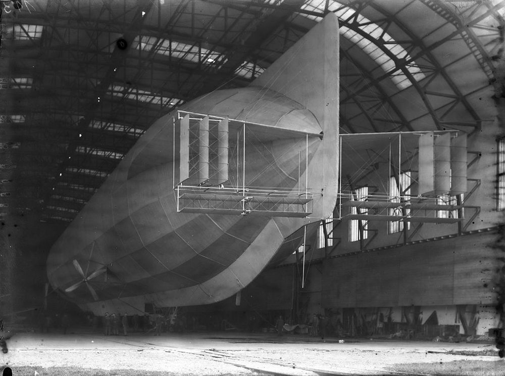 Die historische Aufnahme zeigt den hinteren Teil eines Luftschiffs, das in einer Luftschiffhalle steht.