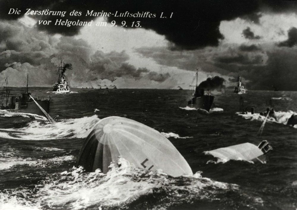 Die schwarz-weiß Abbildung zeigt ein zerbrochenes Luftschiff, welches in einem stürmischen Meer versinkt. Im Hintergrund sind vier Schiffe abgebildet.