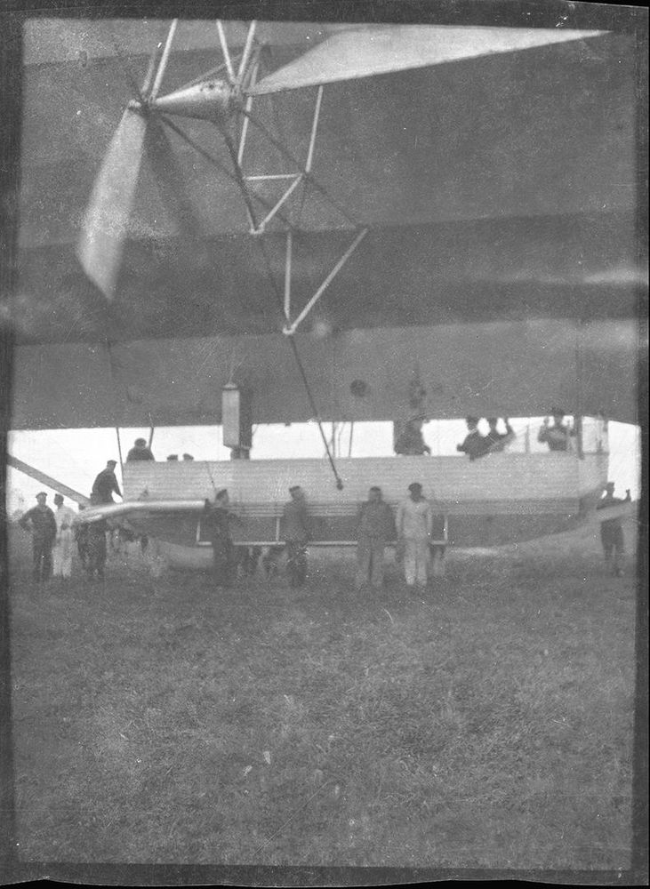 Die historische Aufnahme zeigt mehrere Männer die in und um eine Luftschiffgondel stehen.