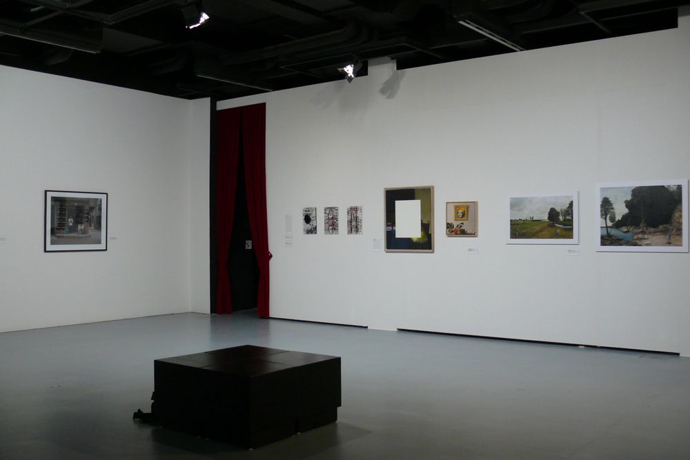 Die Ausstellungsansicht zu "Gestochen scharf" zeigt einen großen und leeren Raum, an dessen Wänden verschiedene Bilder hängen. 