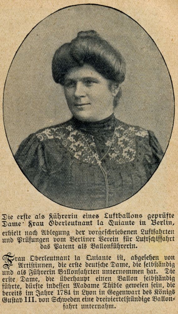Die Abbildung zeigt den Ausschnitt eines Zeitungsberichts von 1908. Über einem Text ist in einem ovalen Kreis ein Porträt platziert. Das Bild zeigt eine Frau mit hochgesteckter Frisur, die eine bestickte Bluse trägt. 