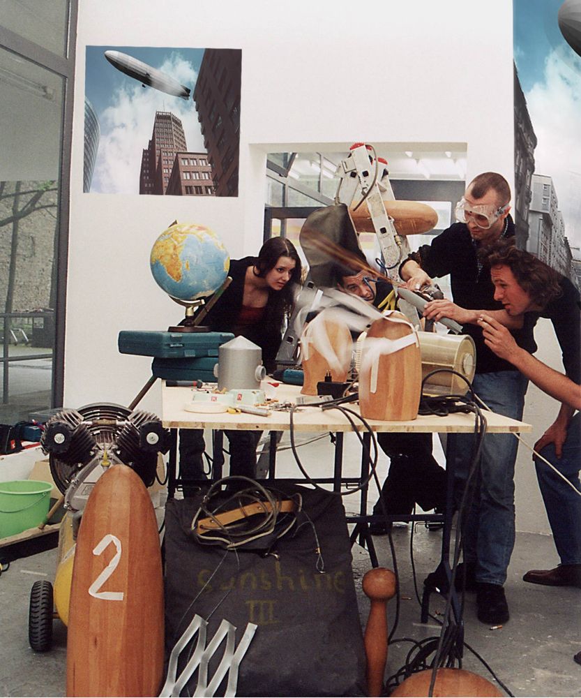 Eine Gruppe von Menschen tüftelt an einem Ausstellungsexponat.