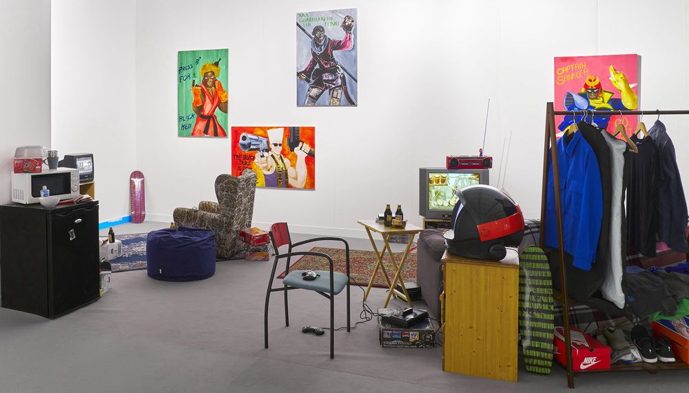 Installationsansicht von Larry Achiampongs Jugendzimmer mit Kleidung, Möblen und Spielkonsolen.