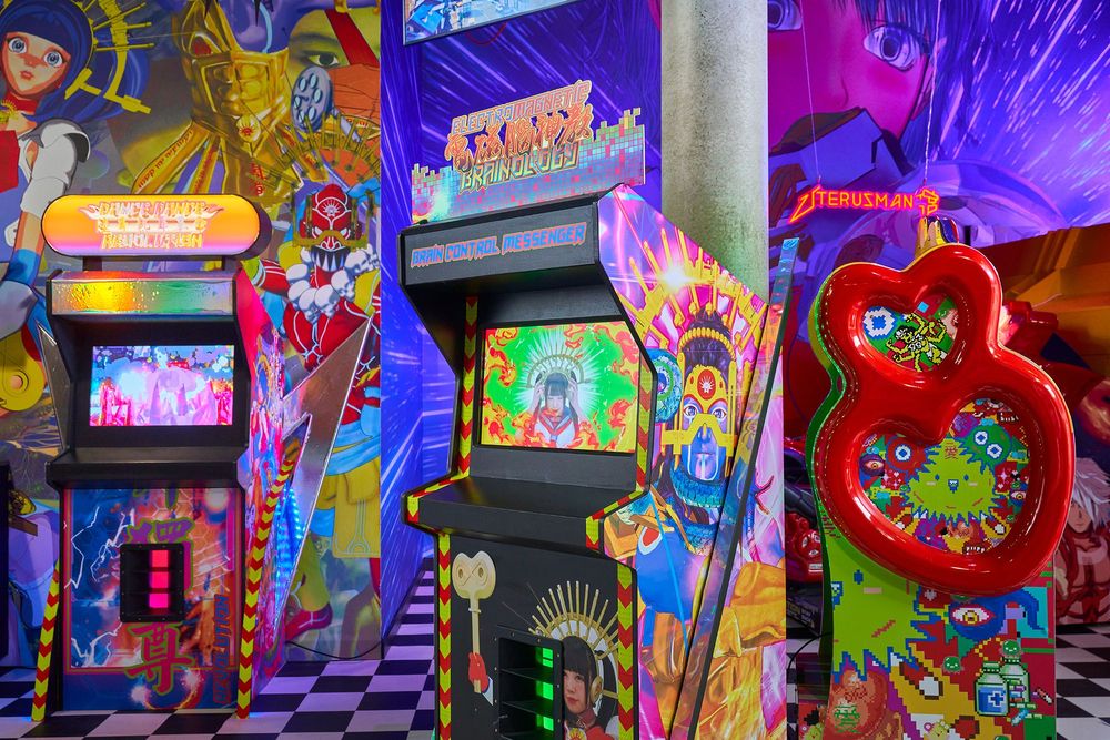Installationsansicht auf zwei Spielautomaten und einem Aufsteller mit zwei roten Herzen.