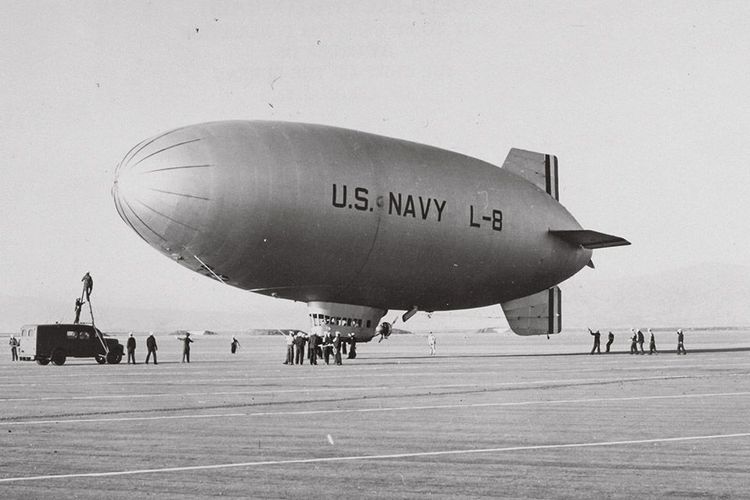 Die historische Aufnahme zeigt ein Prallluftschiff auf einem Flugplatz.