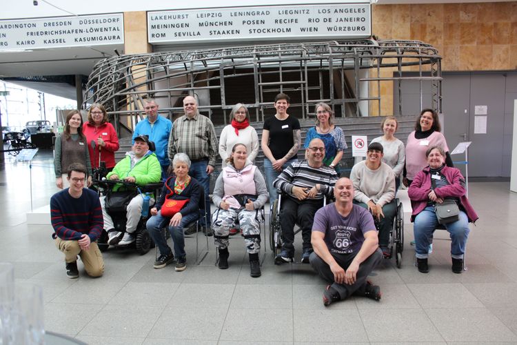 Die Inkluencer*innen und Mitarbeiter*innen von INIOS und capito Bodensee sowie die Museumsmitarbeiterinnen Jana Dix und Sabine Ochaba stehen im Foyer des Zeppelin Museums vor einer Motorgondel. 
