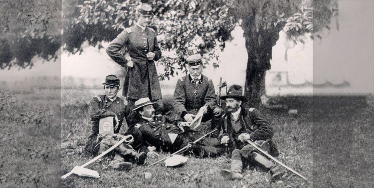 Historische Aufnahme des Grafen von Zeppelin mit vier weiteren Männern um sich herum, die auf einer Wiese sitzen.