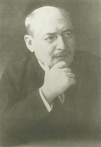 Brustbild von Prof. Dr. Hugo Hergesell im Anzug. Er trägt einen Oberlippenbart und einen Zwicker auf der Nase. Er hat sein Kinn auf die rechte Hand gestützt.