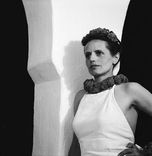 Die schwarz-weiß Fotografie zeigt ein Selbstporträt der Künstlerin Ré Soupault. Sie trägt ein weißes Kleid und Schmuck im Haar und um den Hals. 