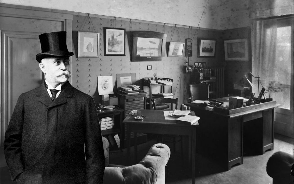 Graf Zeppelin steht in einem Bürozimmer mit alten Möbeln.